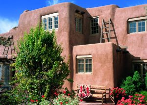 Spanish Pueblo Revival home in Santa Fe with smooth adobe walls and viga ceilings