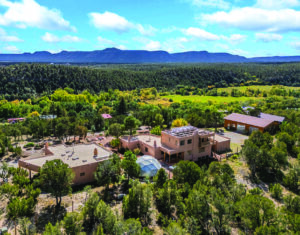 Traditional Santa Fe casita with adobe walls and portal, guest house feature