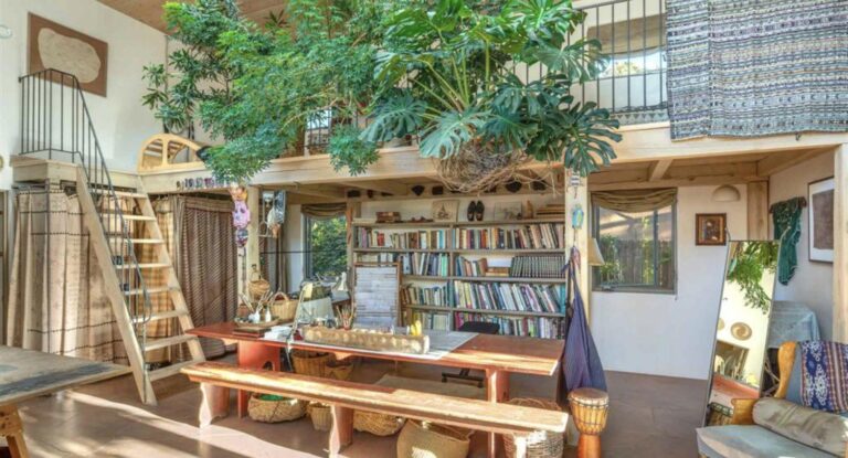 Artist's studio with a loft, bookshelves, work table, and hanging plants at 116 Mesa Verde, Santa Fe
