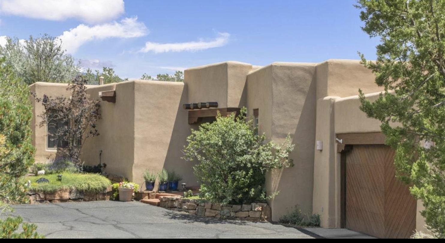 Adobe exterior with stepped parapets and planted courtyard at 1351 Barranca De Oro, Las Barrancas, Santa Fe