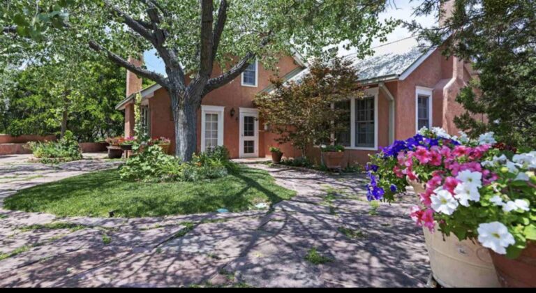 Flagstone courtyard, mature tree and planted beds at 23 Vuelta Muerdago, La Tierra, Santa Fe