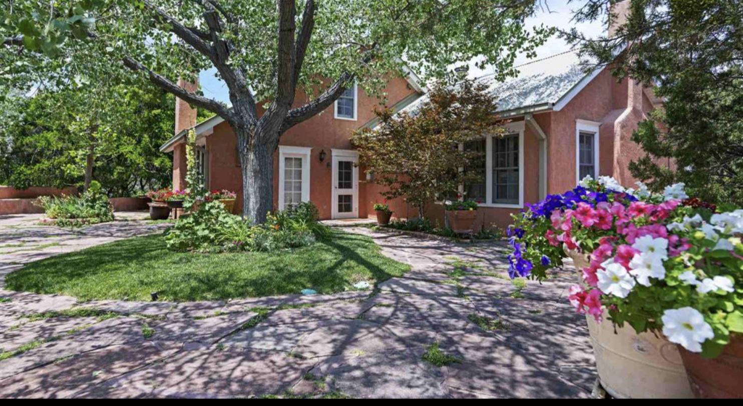 Flagstone courtyard, mature tree and planted beds at 23 Vuelta Muerdago, La Tierra, Santa Fe