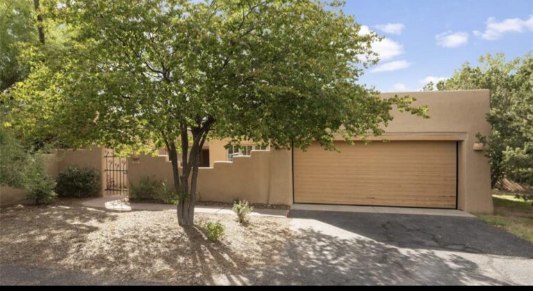 Adobe exterior with a mature tree and attached garage at 3101 Old Pecos #686, Quail Run, Santa Fe