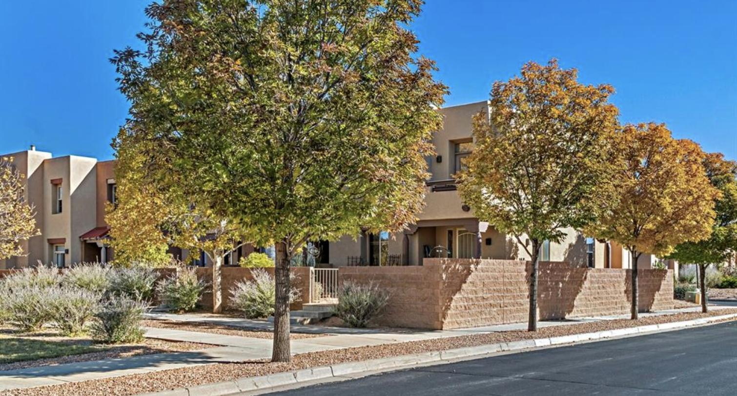 Corner townhome behind autumn trees at 37 Victorio Peak, Rancho Viejo, Santa Fe