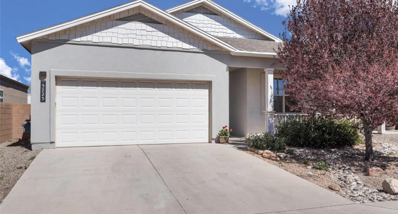 Single level stucco house with an attached two car garage at 5225 Via Del Cielo, Santa Fe