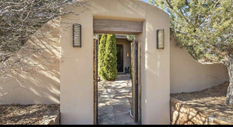Adobe entry gate opening onto the walled courtyard at 73 Thundercloud, Las Campanas, Santa Fe
