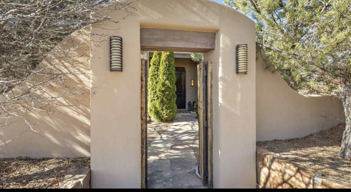 Adobe entry gate opening onto the walled courtyard at 73 Thundercloud, Las Campanas, Santa Fe