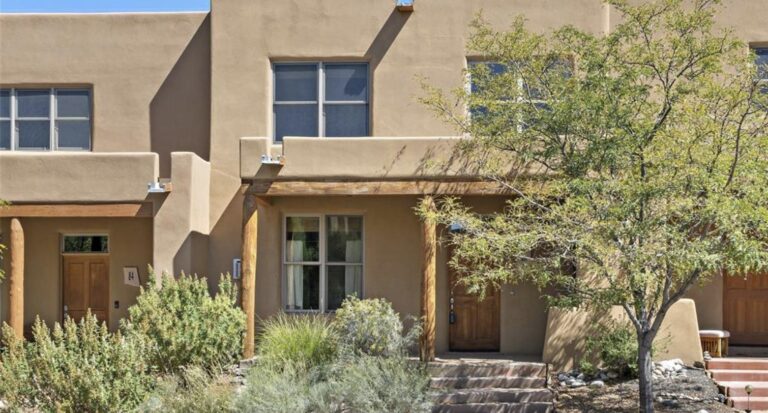 Two story adobe townhome with a covered portal at 82 Avenida Frijoles, Aldea de Santa Fe
