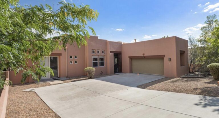 Single level stucco house with a two car garage and xeriscaped yard at 98 Canada Del Rancho, Santa Fe
