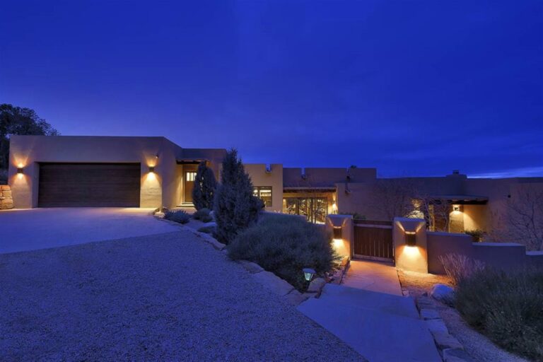 A contemporary Santa Fe home at dusk, lit from within