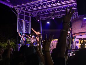 Souls of Mischief performing under purple stage lights with the crowd's hands raised at Raashan Ahmad's Hip Hop Festival, Santa Fe Railyard Plaza, August 2026.